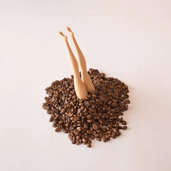 Aşırı dozda kahve çekirdeğinden çıkan bebek bacakları. Yaratıcı kahve içeceği konsepti. Eşsiz düzlük.