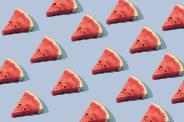 Güneş ışığı deseni parlak mavi arka planda karpuz meyvesinden yapılmıştır. Minimum gıda kavramı.