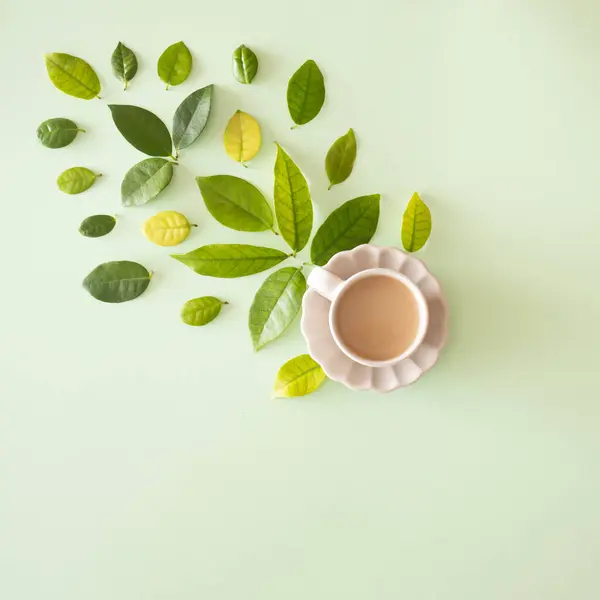 Yeşil ve sarı yapraklı yaratıcı bir kavram ve parlak bir arka planda yüksek dozda kahve.