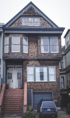 Klasik San Francisco binası ahşap ön cepheli ve koyu pencereli. Konut binasında tuğla merdiven, garaj ve ön giriş var. Yoğun bir şehir ortamında kenar mahalle cazibesi.