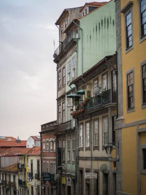 Porto 'daki renkli eski binalar, dövmeli demir balkonları ve pastel cepheleri var. Tipik Portekiz tarihi şehir merkezi manzarası, şehir cazibesi ve karakteriyle dolu..