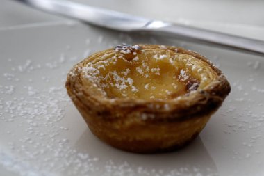 Ev yapımı Portekiz Kremalı Turtası (Pastel de Nata) krema şekerli bir tabakta yakın plan