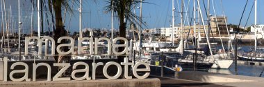 ARKIŞ, LANZAROTE, CANAROTE ADAKLARI - 13 Şubat 2025: Lanzarote Marina 'nın arka planında tekneler olan büyük tabelalı panorama