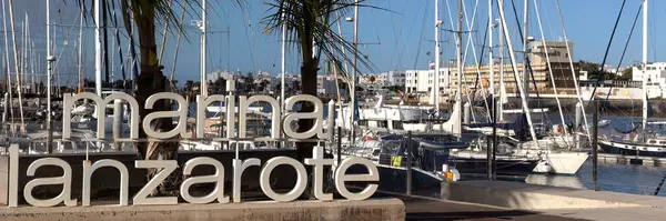 ARKIŞ, LANZAROTE, CANAROTE ADAKLARI - 13 Şubat 2025: Lanzarote Marina 'nın arka planında tekneler olan büyük tabelalı panorama