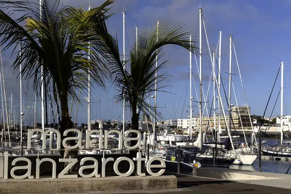 ARKIŞ, LANZAROTE, CANAROTE ADALARI - 13 Şubat 2025: Lanzarote Marina için arka planda botlu büyük işaret