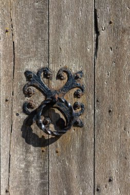 Eski meşe kapısında dövülmüş demir kapı tokmağı.