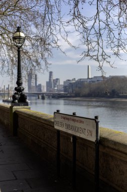 LONDON, İngiltere - 19 Mart 2025: Arka planda Thames Nehri ve Londra 'nın merkezi ve Battersea Skyline ile Chelsea Embankment için imza