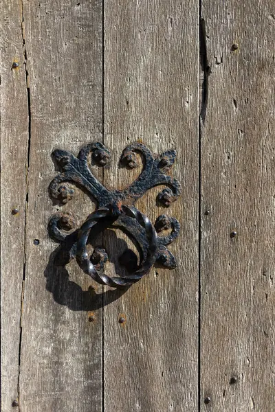 Eski meşe kapısında dövülmüş demir kapı tokmağı.