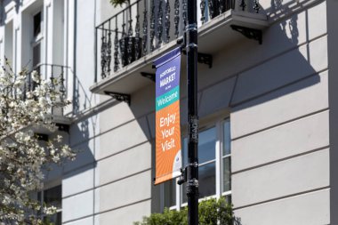 LONDON, İngiltere - 29 Mart 2025: Mavi gökyüzüne karşı izole Portobello Road Market için renkli karşılama tabelası