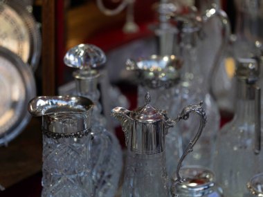 LONDON, İngiltere - 29 Mart 2025: Portobello Road Market 'teki antika bir tezgahta gümüş ve kristal sürahiler