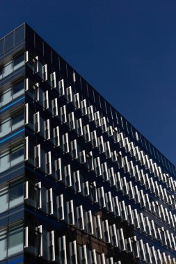 LONDON, İngiltere - Nisan 01, 2025: Londra şehrindeki 33 Aldgate High Street binasındaki pencerelerin soyut görüntüsü mavi gökyüzüne karşı izole edilmiş