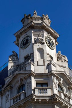 LONDON, İngiltere - 1 Nisan 2025: Finsbury Meydanı 'ndaki He Alphabeta binasında mavi gökyüzüne karşı izole edilmiş küçük saat kulesi