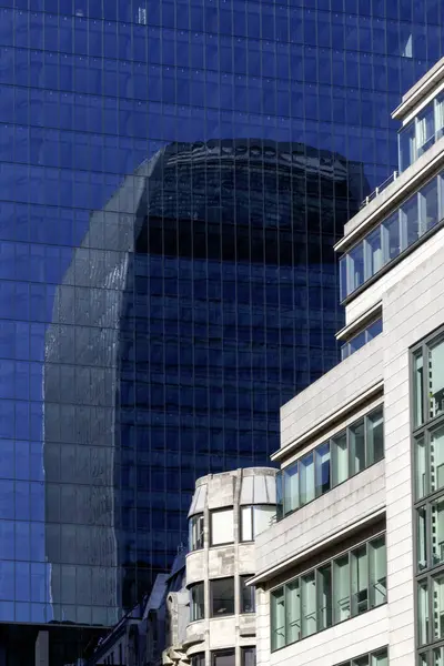 LONDON, İngiltere - Nisan 01, 2025: Walkie Talkie binası (20 Fenchurch Caddesi) 8 Bishopsgate binasına yansıdı