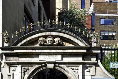 LONDON, İngiltere - 30 Nisan 2025: St. Olave Kilisesi mezarlığına giriş başakları ve kafatasları ile Hart Caddesi 'nde kesişen kemikler