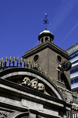 LONDON, İngiltere - 30 Nisan 2025: St. Olave Kilisesi mezarlığına giriş başakları ve kafatasları ile Hart Caddesi 'nde kesişen kemikler