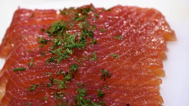 Yiyecek pazarındaki balıkçıların tezgahının tepesine maydanoz serpiştirilmiş somon (Gravlax) yakın plan.