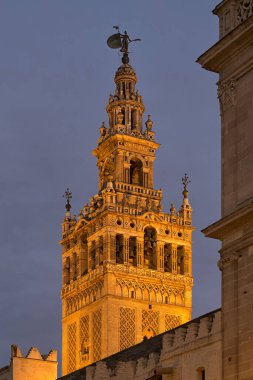 SEVILLE, İspanya - 14 Mart 2016: Seville Katedrali 'nin Giralda Çan Kulesi' nin dış manzarası gece aydınlandı