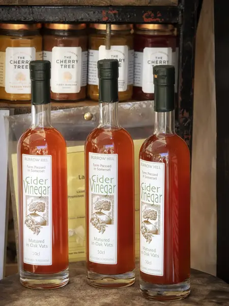 LONDON, İngiltere - 29 Eylül 2018: Bir gıda pazarındaki tezgahta Burrow Hill elma sirkesi şişeleri