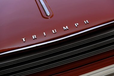 LONDON, İngiltere - 31 Mayıs 2025: Kırmızı Triumph Herald Convertible klasik arabanın krom adı