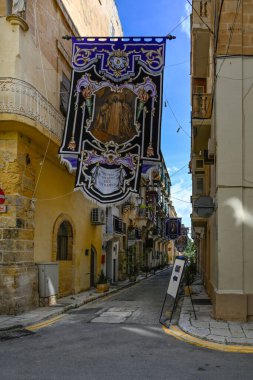 VALLETTA, MALTA - 18 Nisan 2025: Triq M.Caruana Caddesi 'ndeki Saint Publius Kilisesi' ne yakın dini bayrak
