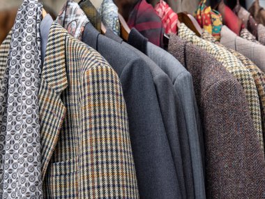 Erkek ceketleri bir markette elbise korkuluğuna asılmış.