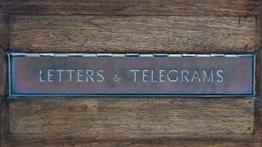 Mektuplar ve telgraflar, ahşap kapıdaki eski pirinç posta kutusuna yazılmış.