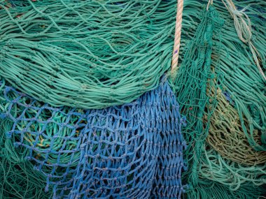 Green and blue fishing nets on a quayside