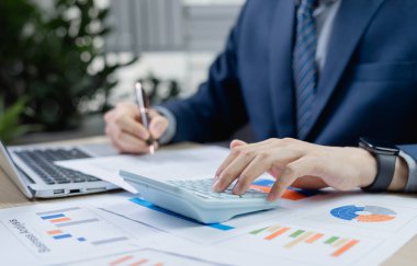 Vergi indirimi konsepti. Mali dengeyi hesaplayan işadamı, vergi indirimi, iş muhasebesi ve yıl sonu mali planlama için belgeler hazırlıyor.