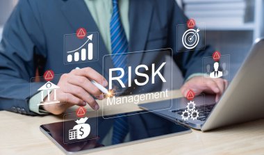 Potansiyel riskleri analiz eden işadamı, hasarı azaltmak için stratejiler geliştiren, finans değerlendirmesi yapan ve işletmelerin korunması için girişim risk yönetimini uygulayan bir işadamı.