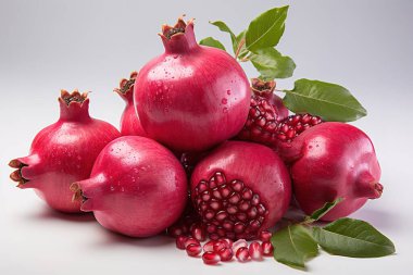 Canlı, kırmızı nar, taze hasat edilmiş ve el değmemiş beyaz bir yüzeyde sergilenmiş, doğal sağlıklı besinlerin özünü yakalıyor. Bu durgun yaşam makrosu olgun meyvenin yeşil yapraklar ve dışkılarla birlikte su damlacıklarıyla parıldadığını gösteriyor.