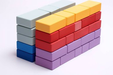 Canlı, izole, renkli ahşap bloklar istiflenmiş, inşaat ve bina kavramları sergileniyor. Eğitim, tasarım ve yaratıcı projeler için mükemmel, bu resim geometrik desenler içerir.