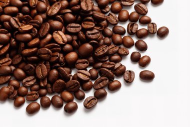 Zengin, kavrulmuş kahve çekirdekleri el değmemiş beyaz arka planda ustalıkla sergileniyor. Bu makro çekim, espresso, kafe ve gurme içecek kavramları için mükemmel aroma ve dokuya vurgu yapıyor..