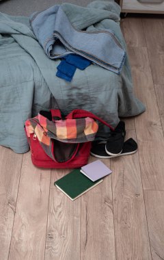 Bir çift çocuk ayakkabısı, dağınık kitaplar ve odanın zemininde kırmızı renkli bir sırt çantası var. Temizlik ve disiplin. Dökülüyor