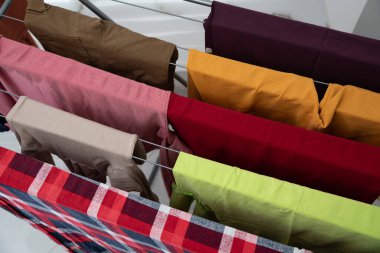 Parlak renkli giysiler evde askıda kurutuluyor, tazelik, rahatlık ve temiz yaşam tarzı kavramı