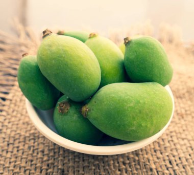 Olgunlaşmamış bir mango, basit ve organik yiyecek fotoğrafçılığı..