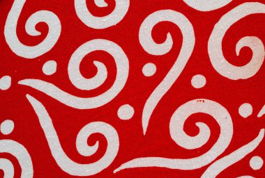 Beyaz kıvrımlı ve noktalı kırmızı batik kumaş..
