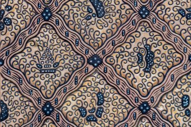Karmaşık girdap ve motiflerle detaylandırılmış batik duvar deseni. Geleneksel Endonezya sanat ve zanaatkarlığını yakından gösteren kültürel tekstil tasarımı.