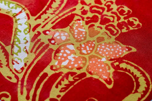 Batik kumaş, kırmızı, turuncu, sarı ve beyaz çiçekli desenler. Geleneksel Endonezya tekstil sanatı