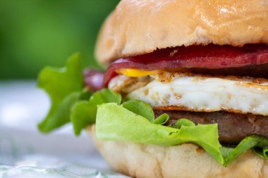 Avustralya eti ve taze sebzelerle sulu bir hamburger.