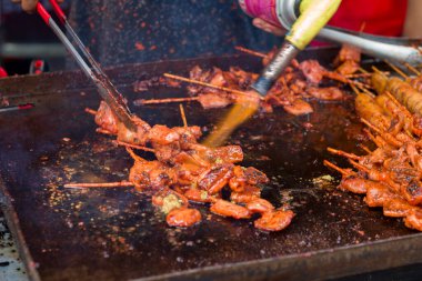 Kalamar satay, bir yemek festivalinde alev tabancasıyla ızgara yaptı.