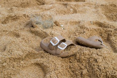 Neredeyse kumsala gömülecek olan sandaletler.