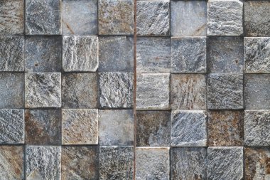 Kare kareyle kaplanmış yüzey, gri ve kahverenginin değişik tonlarında desenli taşlar, mozaik benzeri bir desen yaratıyor..