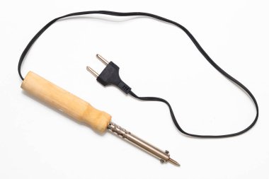 Ahşap saplı lehim demiri, siyah kablosu ve beyaz bir yüzeyde duran iki uçlu dolgusu..