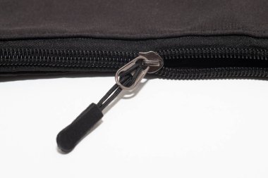 Siyah kumaş çanta, parlak, plastik fermuarlı metalik çekiş sekmeli, beyaz arka plana ayarlı..