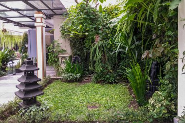 Sergilenen sakin açık hava bahçesi yemyeşil yapraklar, geleneksel bir taş pagoda ve süs heykelleri, huzur verici bir vaha yaratıyor..