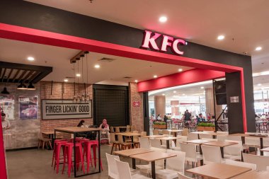 KFC restoranının içinde, simgesel kırmızı ve siyah markasını sergiliyor.