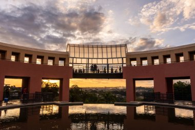 Brezilya, Paran 'ın başkenti Curitiba' daki Tangu Şehir Parkı binası ve su fıskiyelerine güzel gün batımı manzarası.