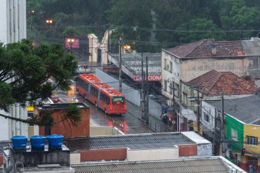 Şehir merkezindeki yağmurlu caddenin köşesinde Paran, Brezilya 'nın başkenti Curitiba' nın bulunduğu otobüse bakın..