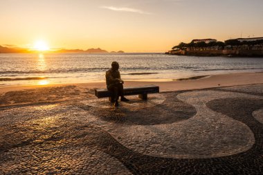 Şair heykeli için güzel bir gün doğumu manzarası Copacabana, Rio de Janeiro, Brezilya plaj bankında oturuyor.