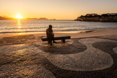 Şair heykeli için güzel bir gün doğumu manzarası Copacabana, Rio de Janeiro, Brezilya plaj bankında oturuyor.